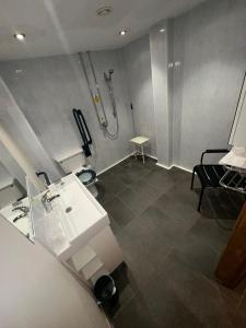 uma casa de banho com um lavatório e um chuveiro em Afan Lodge em Port Talbot