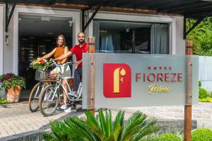 um homem e uma mulher numa bicicleta ao lado de uma placa em Hotel Fioreze Primo em Gramado