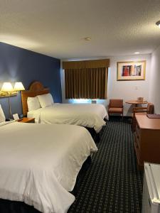 Habitación de hotel con 2 camas y escritorio en Columbus Inn en Columbus