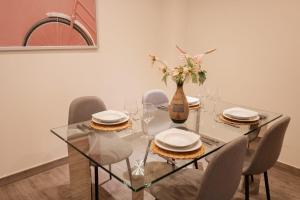 a dining room table with chairs and a vase with flowers at Apartamento Cuzco in Trujillo