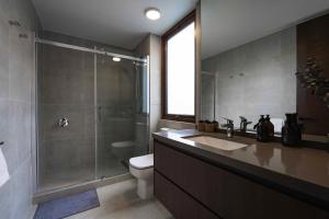 uma casa de banho com um chuveiro, um lavatório e um WC. em Edificio HOME em Santiago