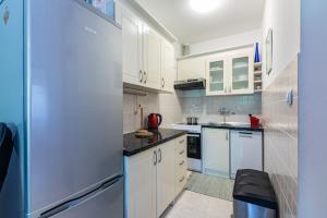 uma pequena cozinha com armários brancos e um frigorífico em Apartment Laurus em Vantacići