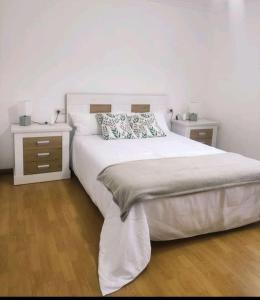Veiga de Cima في Puente Caldelas: غرفة نوم بسرير كبير مع مواقف ليلتين