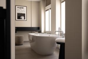 a white bath tub in a bathroom with a window at BEAUMONT Maastricht in Maastricht