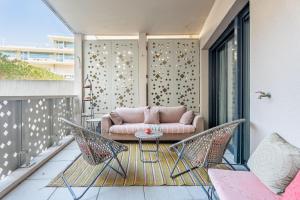 a patio with a couch and chairs on a balcony at Terrasse, Moderne, Centrale in Marseille