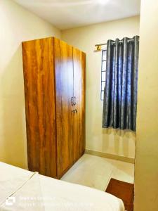 a bedroom with a wooden door and a window at MS Comforts Mahadevapura in Bangalore