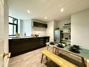a kitchen with a dining table and a kitchen with a counter at Chic 3BR Bournemouth Apt - Near Beach & Shops! in Bournemouth