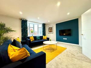 a living room with a blue couch and a table at Chic 3BR Bournemouth Apt - Near Beach & Shops! in Bournemouth