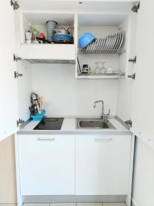 eine Küche mit weißen Schränken und einem Waschbecken in der Unterkunft Rooms&Apartments Hotel Danci in Borghetto Santo Spirito