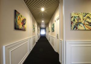 卡沃的住宿－Hotel Levante - Isola d'Elba，建筑墙上的走廊上挂有绘画作品