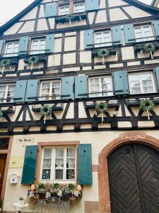 um edifício a preto e branco com janelas e plantas em Historisches Gästehaus Au Faucon em Wissembourg