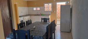 a kitchen with a table with chairs and a refrigerator at Pedro in Balcarce