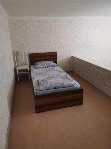 a small bedroom with a bed and a chair at Eminera Hostels Baku in Baku