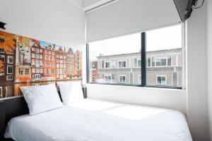 a bedroom with a white bed and a window at easyHotel Amsterdam City Centre South in Amsterdam