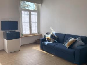 un salon avec un canapé bleu et une télévision dans l'établissement L'Arsenàl, à Trieste