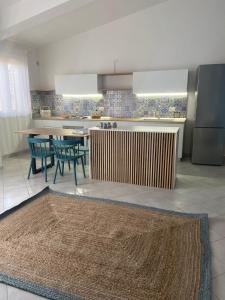 een keuken met een tafel, stoelen en een aanrecht bij Sikuli Home in Oliveri