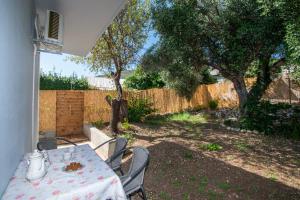 una mesa y sillas en un patio trasero con una valla en Hidden Sea Crest Villa by "elite", en Lithakia