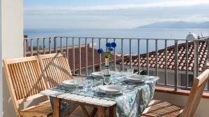 a table on a balcony with a view of the ocean at Green and Blue vista mare Cala Gonone in Cala Gonone