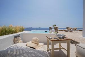 a patio with a table and a tableablish at La Maison Blanche in Agios Stefanos