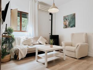 a white living room with a couch and a table at Casa Rural Puebla Deluxe in Puebla de Alcocer