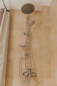 a shower with a shower head in a bathroom at Renovated, open and functional old city house in Heraklio Town