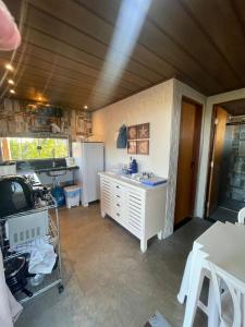 a kitchen with a sink and a refrigerator at Chalé MACAPAZ in Luis Correia