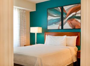 a bedroom with a bed and paintings on the wall at Residence Inn Hartford Manchester in Manchester