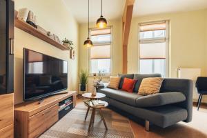 uma sala de estar com um sofá e uma televisão de ecrã plano em Apartment, barrierearm, zentral, 2-3 Personen em Mühlhausen