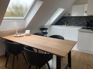 a kitchen with a wooden table and black chairs at Vacanzamare in Wenduine