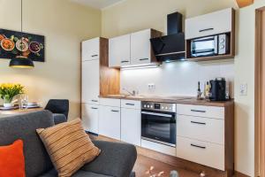 uma cozinha com armários brancos e um forno com placa de fogão em Apartment, barrierearm, zentral, 2-3 Personen em Mühlhausen