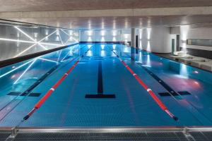 a large indoor swimming pool with blue water at Sofitel Frankfurt Opera in Frankfurt/Main