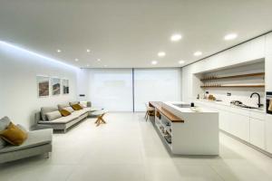 a kitchen and living room with a couch and a table at LEA LUXURY GOLF HOUSE in Caleta De Fuste