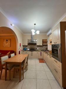 een keuken met een houten tafel en een eetkamer bij Serene Haven Apartment with three specious bedrooms in Marsaxlokk