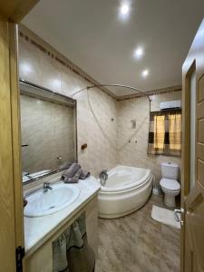 een badkamer met een bad, een toilet en een wastafel bij Serene Haven Apartment with three specious bedrooms in Marsaxlokk