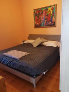 Bett in einem Schlafzimmer mit Wandgemälde in der Unterkunft Appartamento vista mare Lido Scacchi in Lido di Scacchi