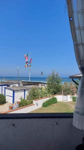 Blick auf den Strand von einem Fenster eines Gebäudes in der Unterkunft Appartamento vista mare Lido Scacchi in Lido di Scacchi
