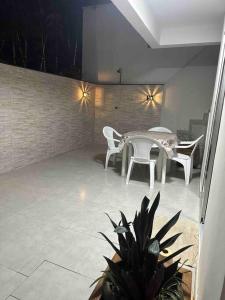 a patio with a table and two chairs and a table and a plant at Ape Katy em Caiobá ao lado do boliche in Matinhos