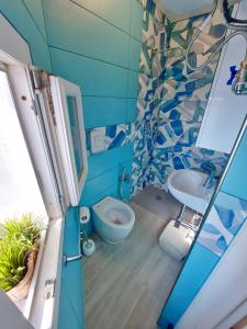 bagno blu con servizi igienici e lavandino di La Casa Azzurra a Procida