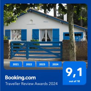 a blue fence in front of a white house at Villa L'Herbaudière - La Baule les Pins in La Baule