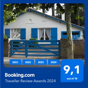 een blauw hek voor een wit huis bij Villa L'Herbaudière - La Baule les Pins in La Baule