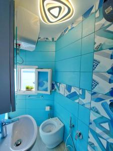 a blue bathroom with a sink and a toilet at La Casa Azzurra in Procida