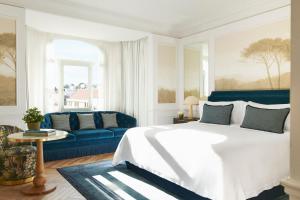 ein Schlafzimmer mit einem Bett und einem blauen Sofa in der Unterkunft The Westin Palace, Madrid in Madrid