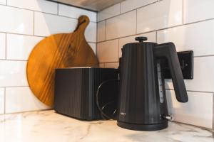 Stunning Central Derby Apartment Free WiFi & Parking في ديربي: آلة صنع القهوة على منضدة في المطبخ
