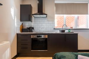 Stunning Central Derby Apartment Free WiFi & Parking في ديربي: مطبخ مع موقد ومغسلة