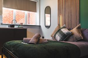 德比的住宿－Stunning Central Derby Apartment Free WiFi & Parking，客房设有带枕头的沙发和窗户。