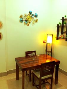 a dining room table with two chairs and a chandelier at JDreamland Homestay in Jorhāt