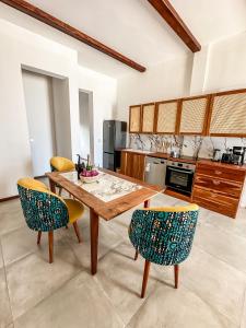 a kitchen with a wooden table and chairs at Just Heaven Apartments in Matemwe
