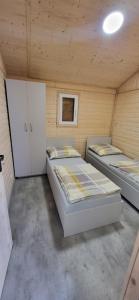 um quarto com 3 camas num quarto de madeira em Jezioro Srebrne w Osowcu em Turawa