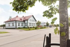 a white house with a red roof on a street at Majoitus Wanhapankki, huoneisto B1 in Kalajoki +1 photo
