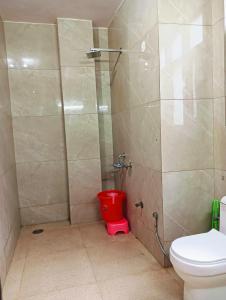 a bathroom with a shower with a red toilet at The White House Shimla in Shimla